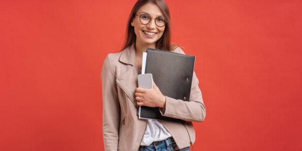 young-smiling-student-intern-eyeglasses-standing-with-folder-red-wall-1-1400x800-1.jpg